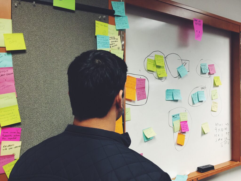 Man planning at a wall of sticky notes during a strategy workshop